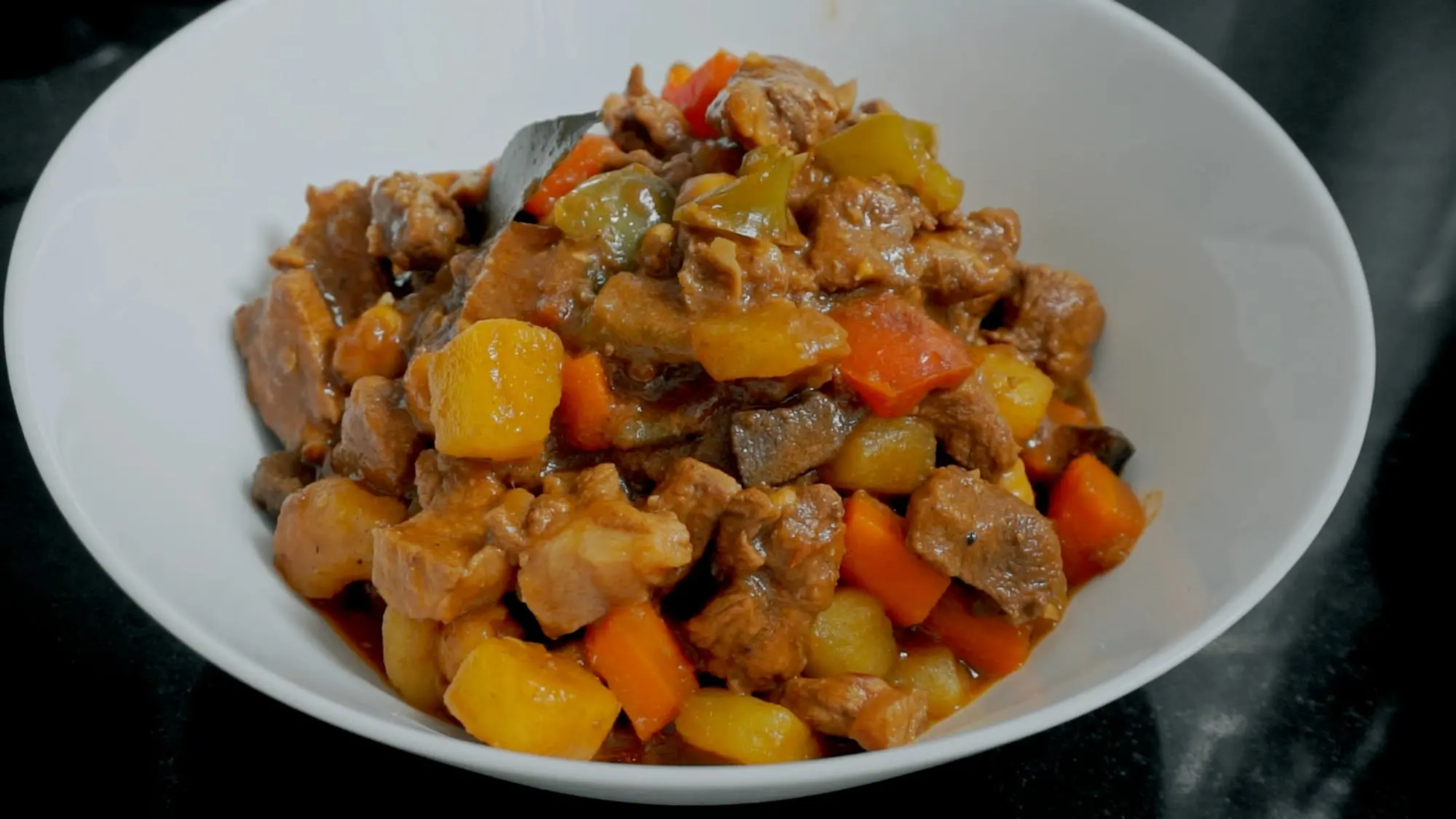 Pork menudo in a white serving bowl