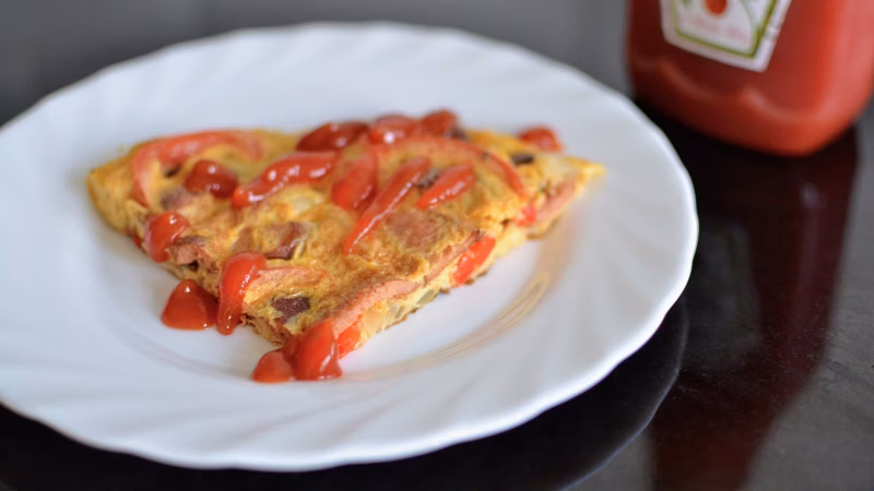 Slice of tortang hotdog with ketchup